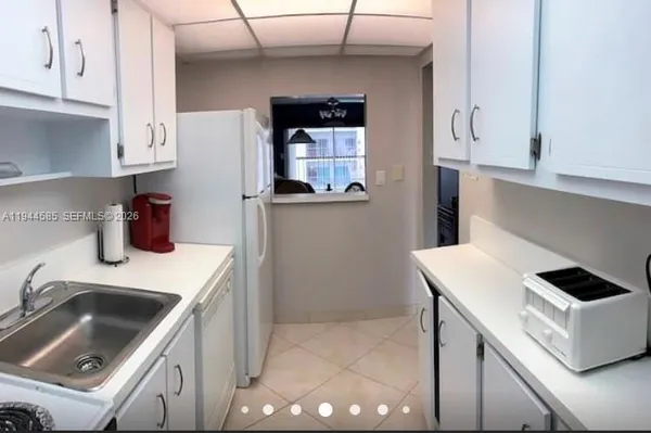 a kitchen with a sink a stove and cabinets