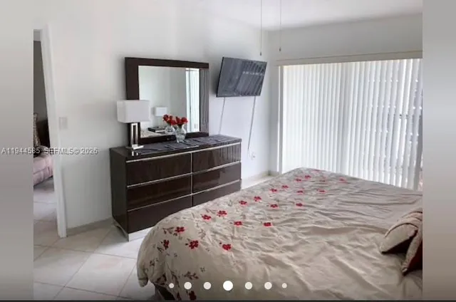 a bedroom with a bed and a mirror on dresser