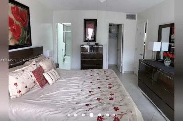 a bedroom with a bed and a mirror on dresser