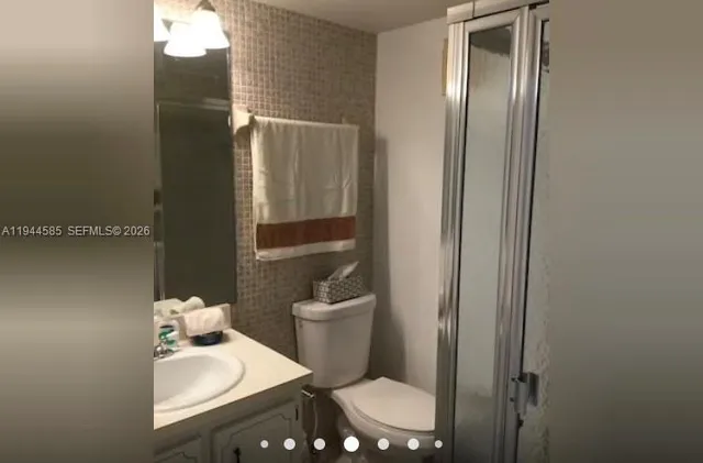a bathroom with a sink vanity mirror and toilet