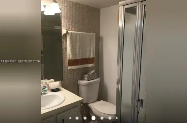 a bathroom with a sink vanity mirror and toilet