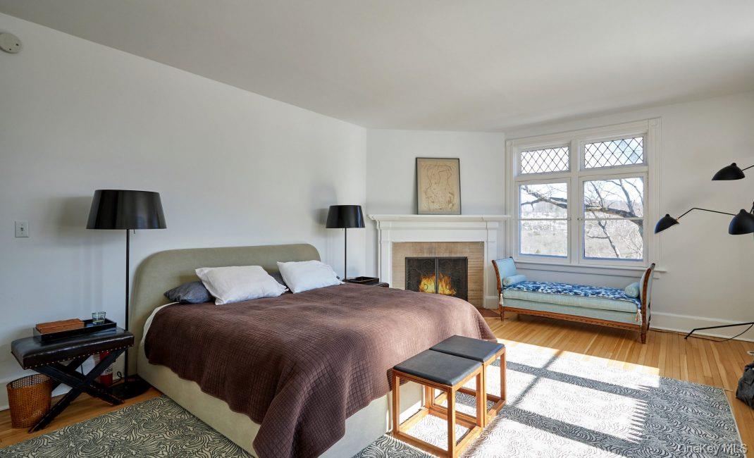 61 Crows Nest Road, Unit 5 Tuxedo Park, NY 10987 - Photo 9 of 16 a bedroom with a bed and a fireplace