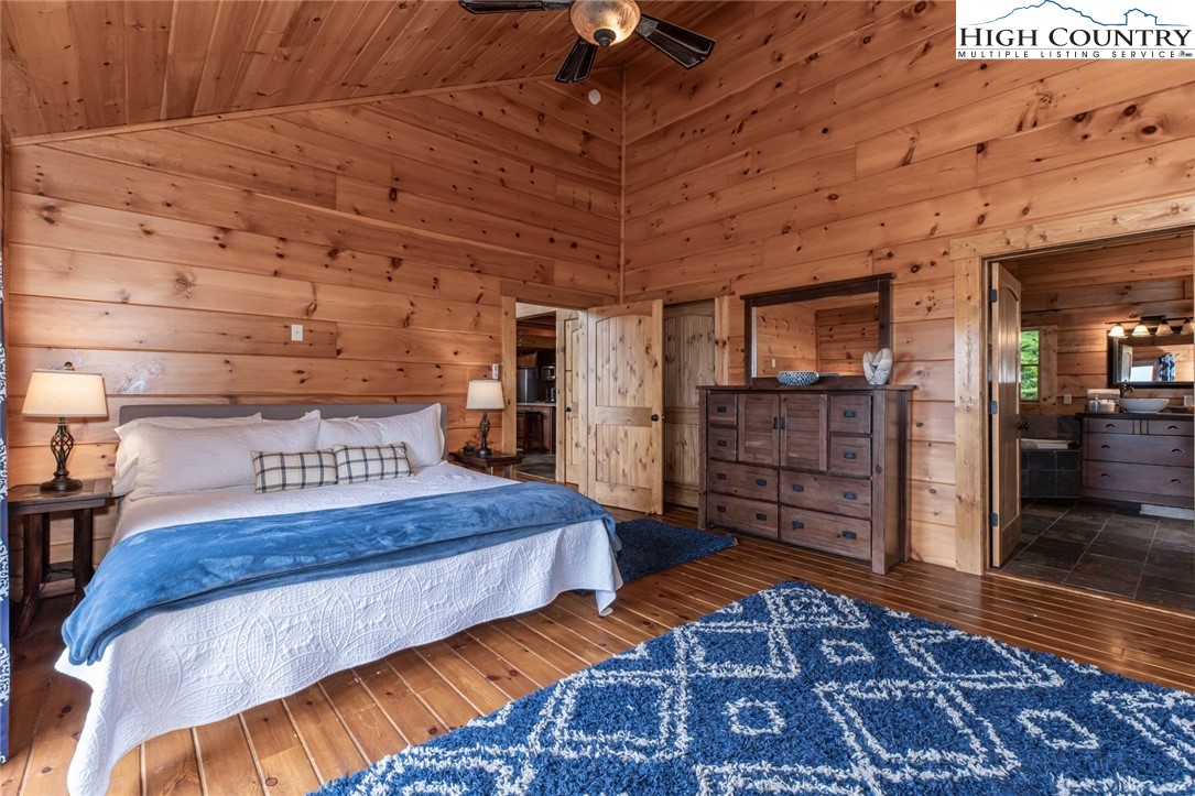 595 Little Squirrel Creek Road Newland, NC 28657 - Photo 17 of 49 a bedroom with a bed and wooden floors