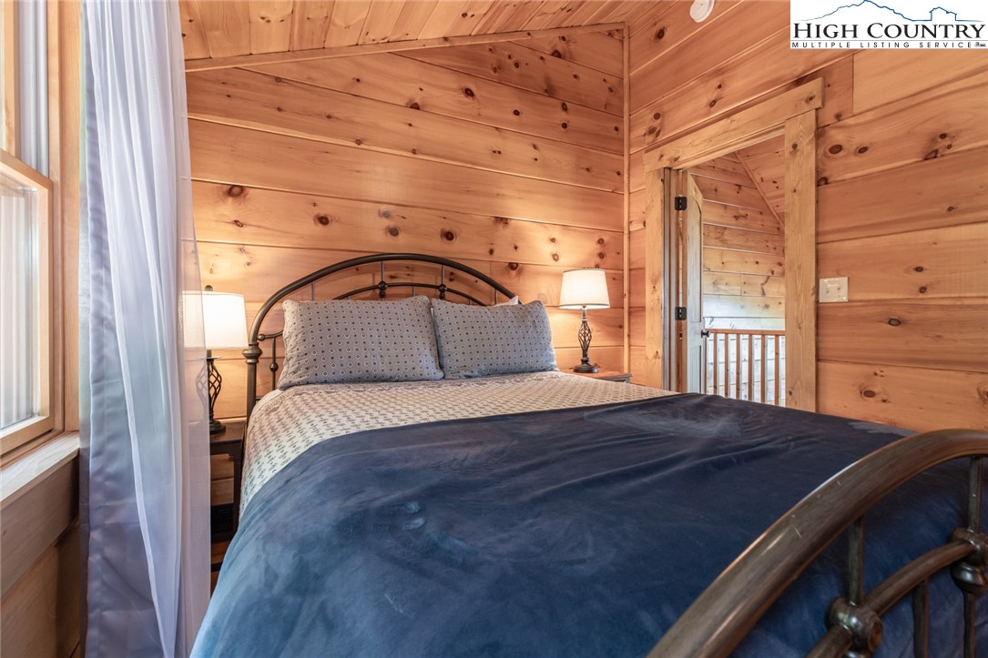 595 Little Squirrel Creek Road Newland, NC 28657 - Photo 22 of 49 a bedroom with a bed and wooden floor