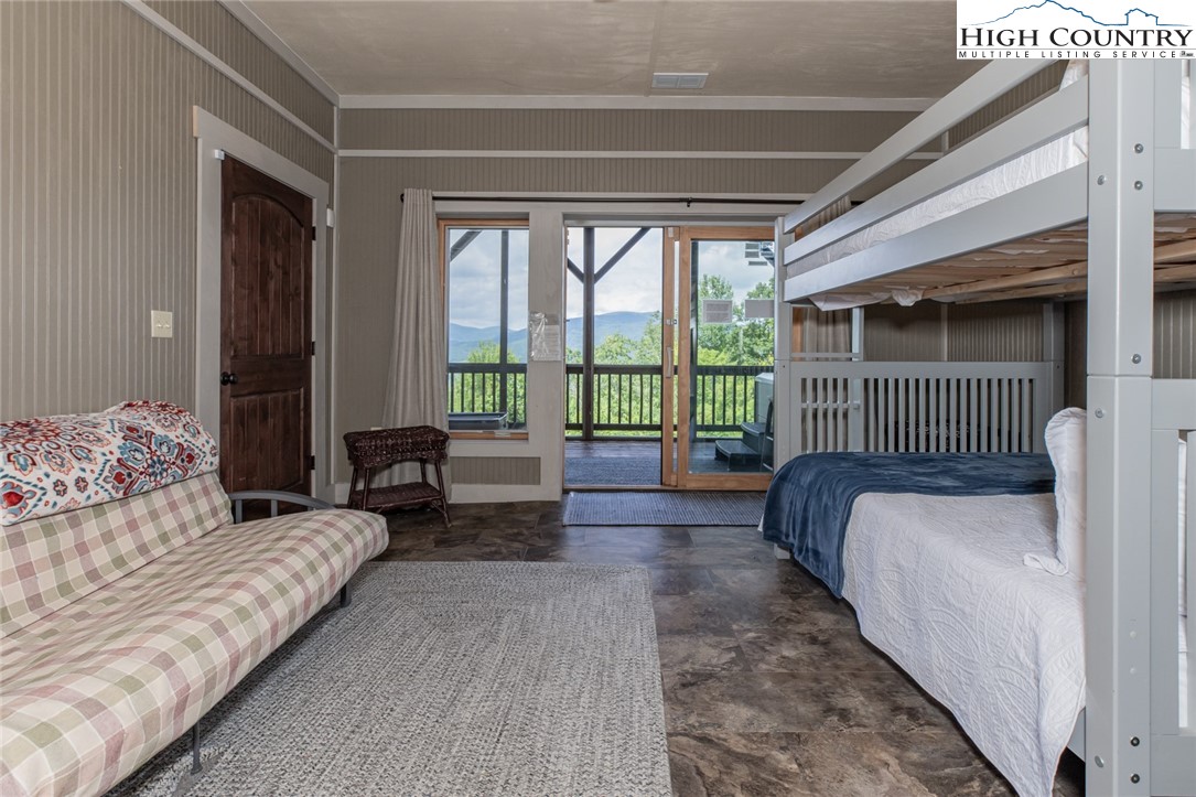 595 Little Squirrel Creek Road Newland, NC 28657 - Photo 33 of 49 a spacious bedroom with a bed and a large window