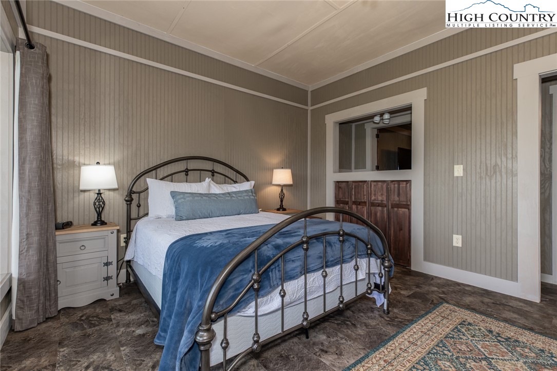 595 Little Squirrel Creek Road Newland, NC 28657 - Photo 39 of 49 a bedroom with a bed and a mirror