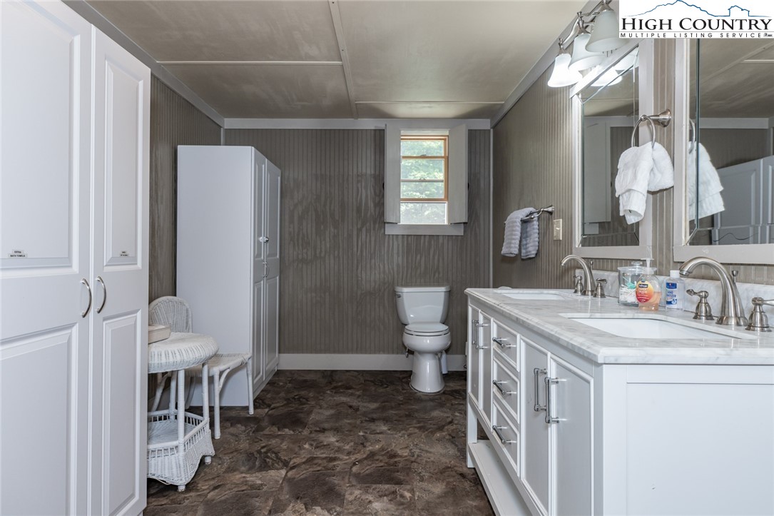 595 Little Squirrel Creek Road Newland, NC 28657 - Photo 40 of 49 a bathroom with a sink a toilet and a mirror