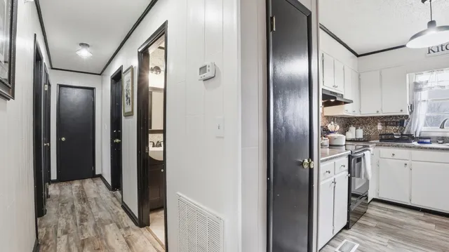 a view of a kitchen with stainless steel appliances granite countertop cabinets and a wooden floor