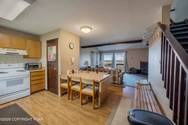a large kitchen with stainless steel appliances a stove a sink dishwasher and a refrigerator with wooden floor