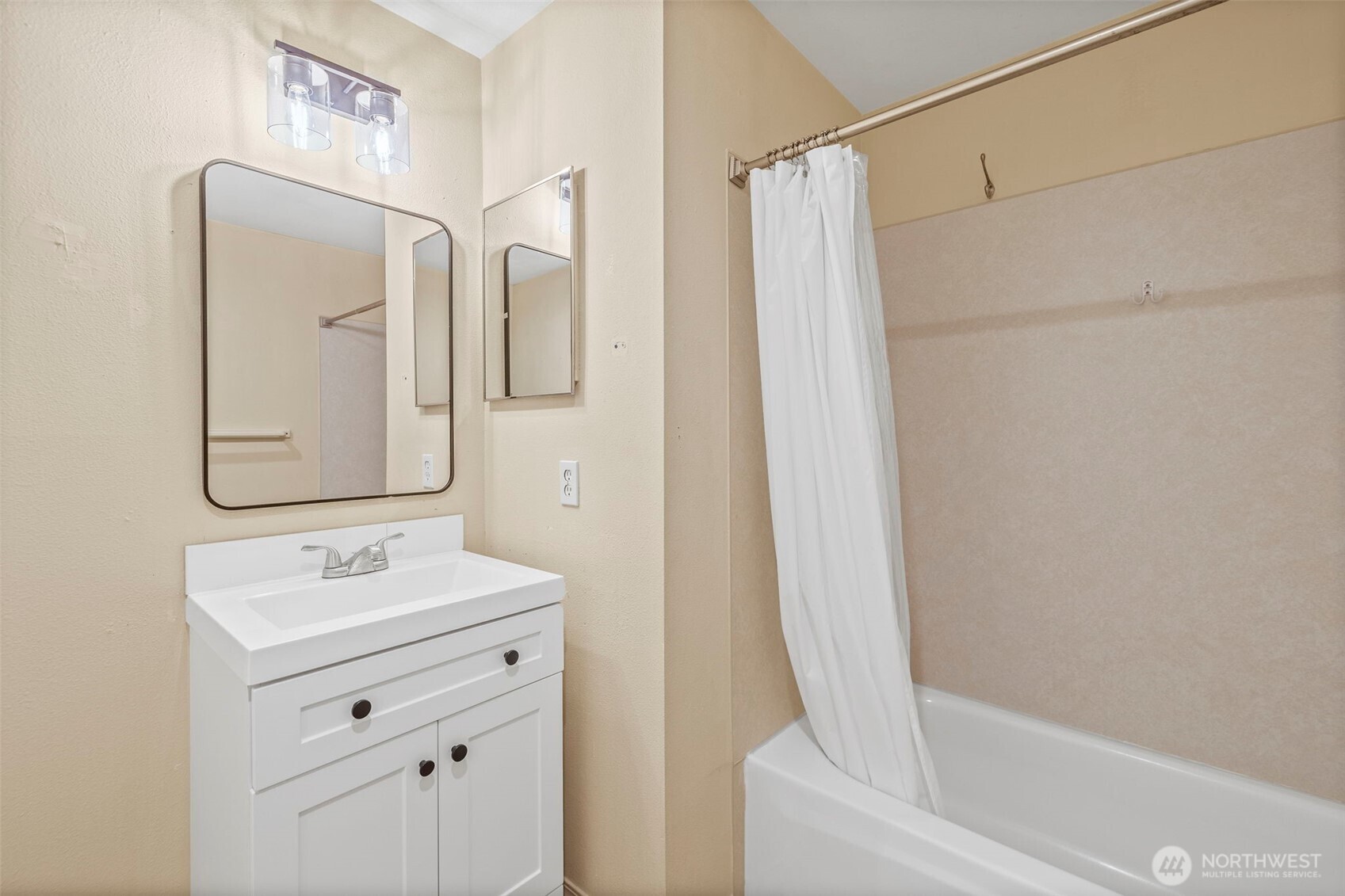 10824 Southeast 170th Street, Unit B103 Renton, WA 98055 - Photo 24 of 31 a bathroom with a sink a mirror a vanity and a bathtub