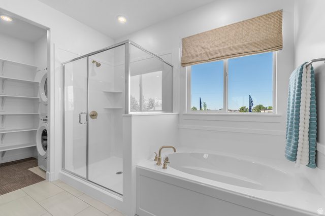 1418 West 2350th South, Unit 15 Perry, UT 84302 - Photo 13 of 22 Spacious bathroom featuring a built-in soaking tub with brass fixtures, a glass-enclosed shower with brass hardware, and a window with a woven Roman shade