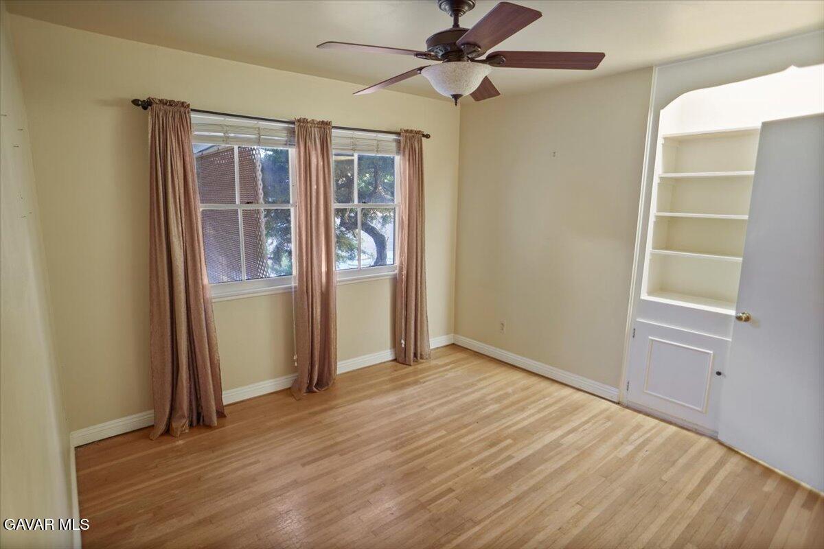 719 West Ave J-10 Lancaster, CA 93534 - Photo 10 of 21 an empty room with wooden floor fan and windows
