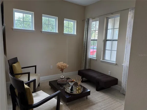 a living room with furniture and two window