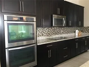 a kitchen with stainless steel appliances wooden cabinets and a stove top oven