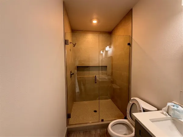 a bathroom with a granite countertop sink toilet and shower