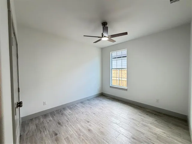 a view of room with window ceiling fan and hardwood floor