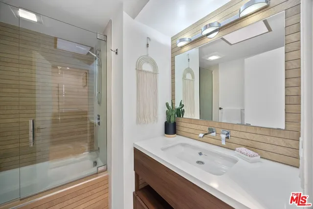a bathroom with a granite countertop sink mirror and shower