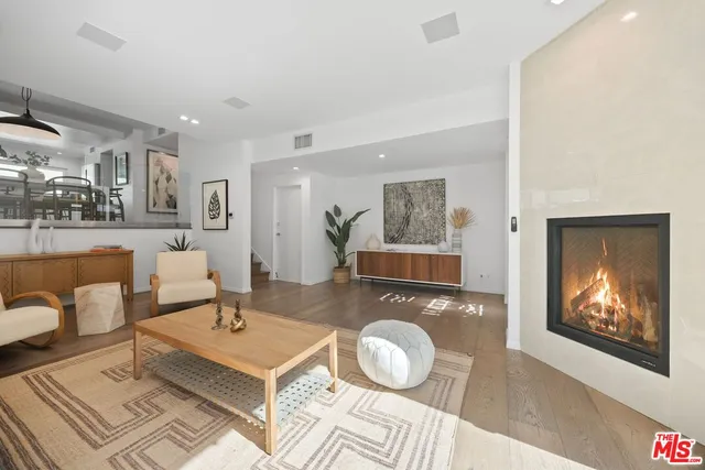 a living room with furniture a rug and wall paintings