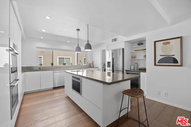 a large kitchen with stainless steel appliances kitchen island a large counter top and a view of living room