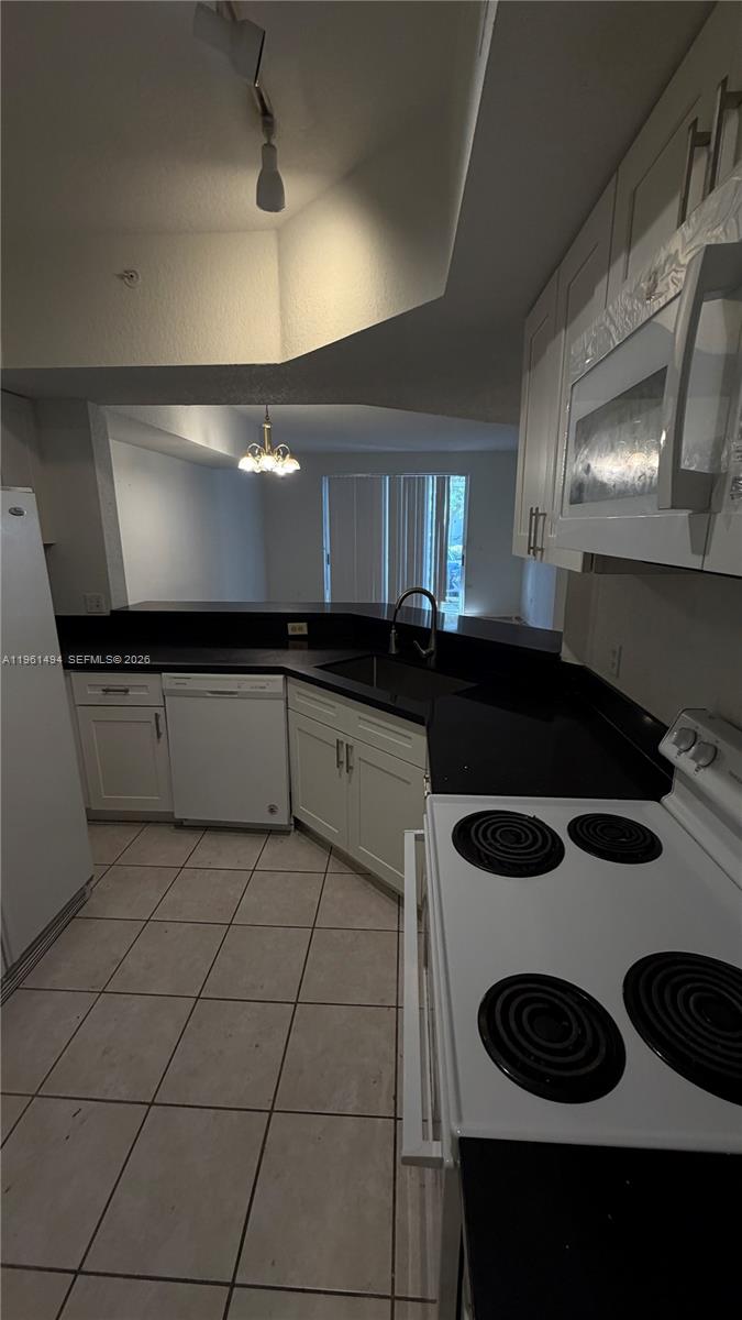 741 Southwest 148th Avenue, Unit 705 Sunrise, FL 33325 - Photo 8 of 32 a kitchen with a sink a stove and cabinets