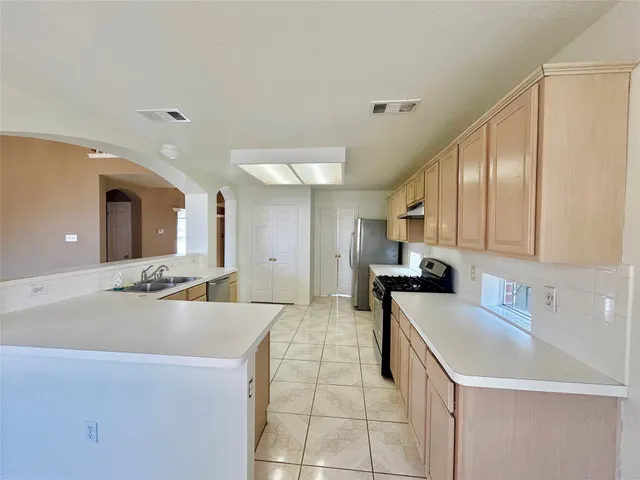 a large white kitchen with a sink and cabinets