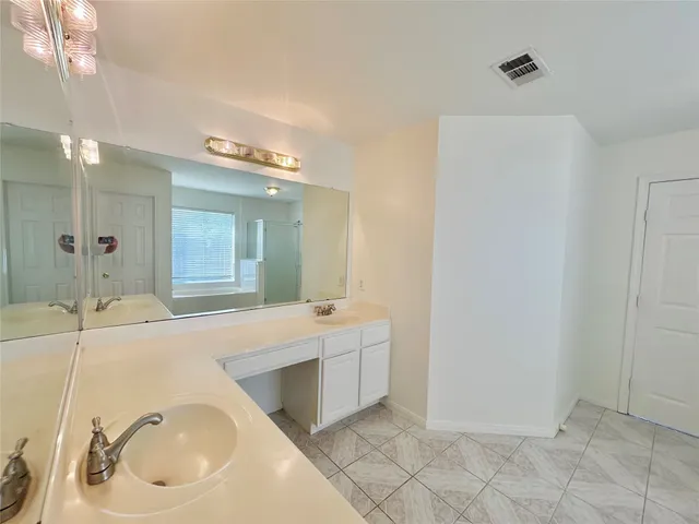 a large bathroom with a tub sink shower and mirror