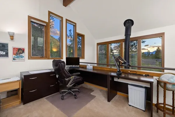 a view of a workspace with furniture and a window