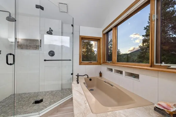 a bathroom with a tub and a large window
