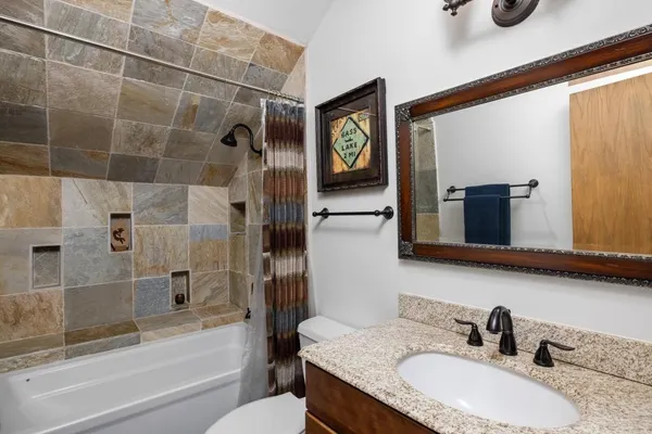 a bathroom with a granite countertop sink and a mirror