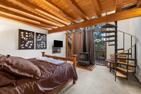 a bedroom with a bed a dresser next to a window
