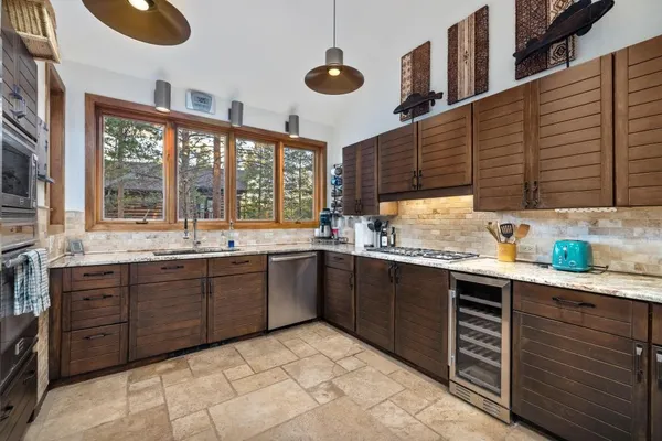 a kitchen with stainless steel appliances granite countertop a sink and a stove