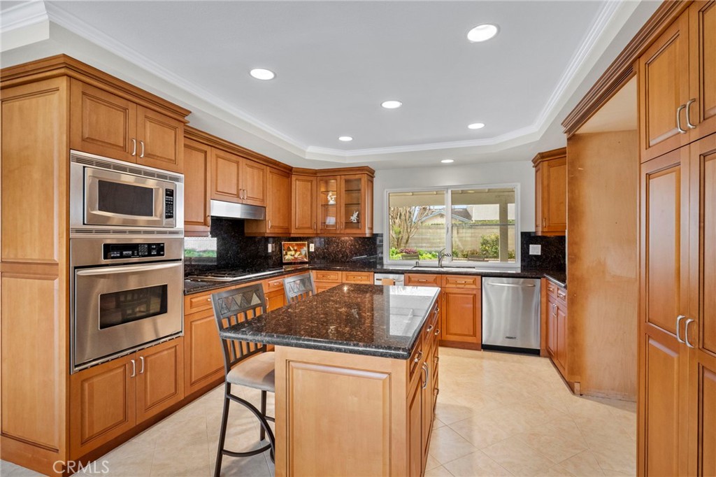 2342 Caper Tree Drive Tustin, CA 92780 - Photo 17 of 44 a kitchen with stainless steel appliances granite countertop a refrigerator a stove top oven a sink and dishwasher