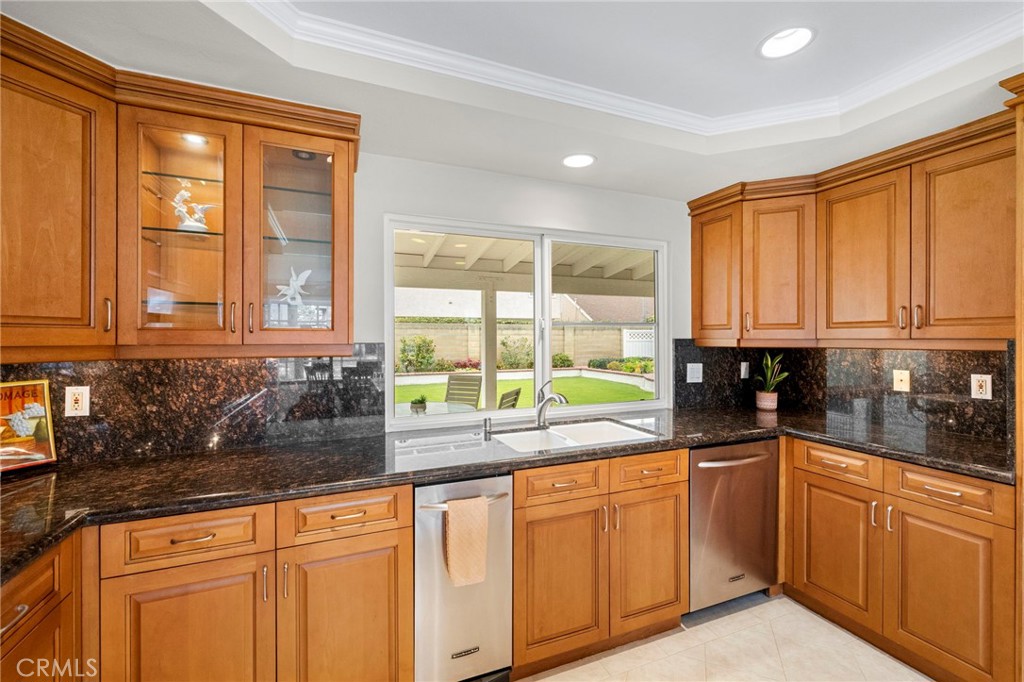 2342 Caper Tree Drive Tustin, CA 92780 - Photo 18 of 44 a kitchen with stainless steel appliances granite countertop white cabinets sink and large window