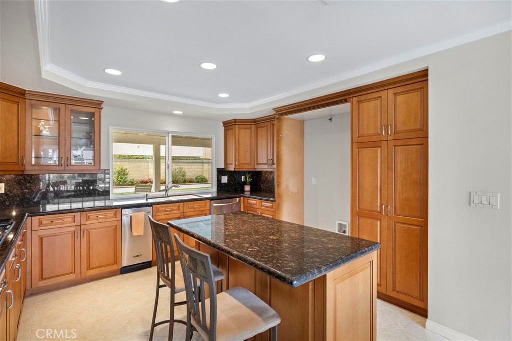 2342 Caper Tree Drive Tustin, CA 92780 - Photo 19 of 44 a kitchen with stainless steel appliances granite countertop a stove top oven a sink dishwasher and a refrigerator with wooden floor
