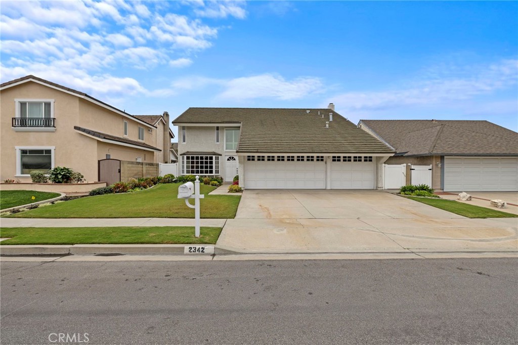 2342 Caper Tree Drive Tustin, CA 92780 - Photo 40 of 44 a front view of a house with a garden and parking space