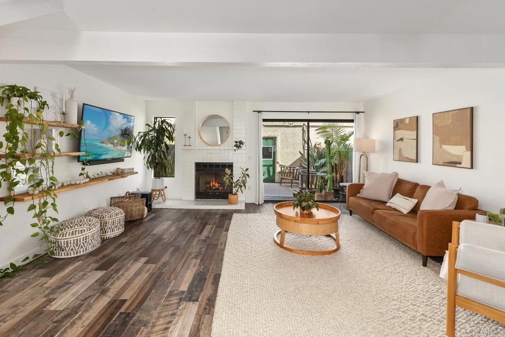 a living room with furniture a fireplace and a flat screen tv