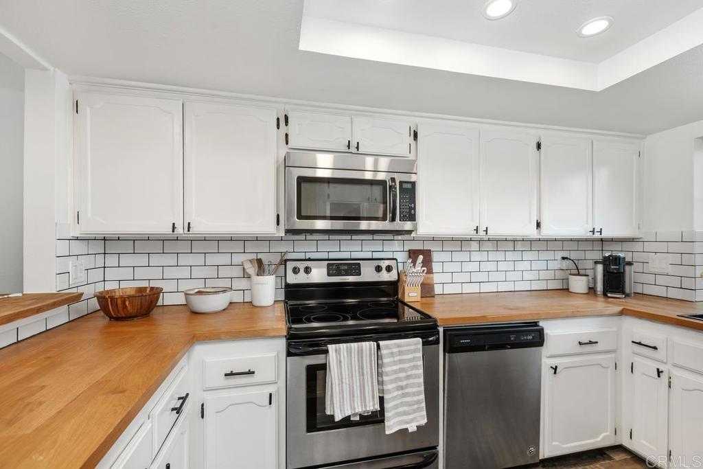 6868 Pear Tree Drive Carlsbad, CA 92011 - Photo 11 of 40 a kitchen with a sink and white cabinets