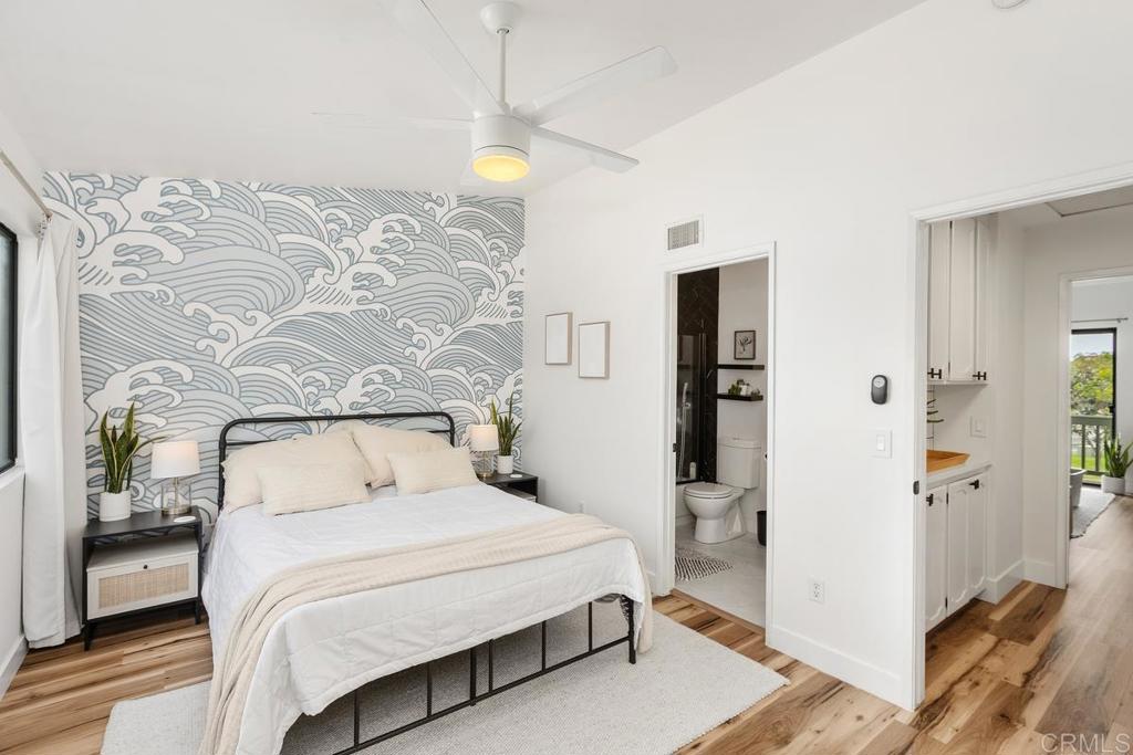 6868 Pear Tree Drive Carlsbad, CA 92011 - Photo 16 of 40 a bedroom with a large bed and a chandelier