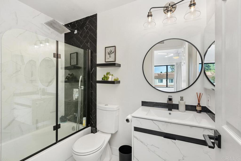 6868 Pear Tree Drive Carlsbad, CA 92011 - Photo 18 of 40 a bathroom with a toilet a sink and a mirror