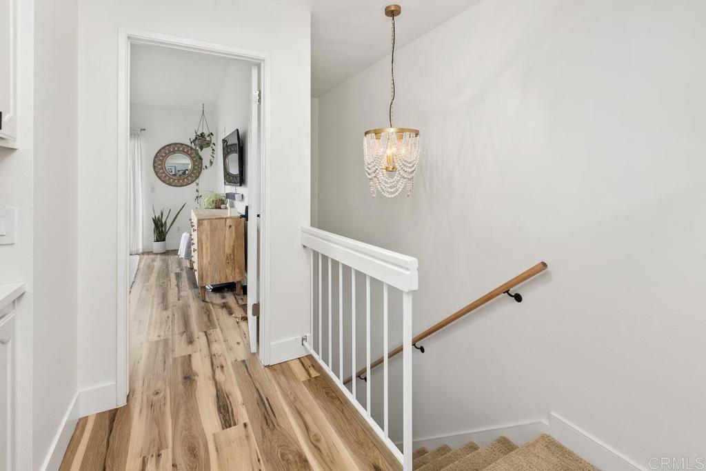 6868 Pear Tree Drive Carlsbad, CA 92011 - Photo 24 of 40 a view of a hallway with wooden floor