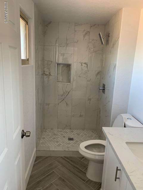 1706 West Colt Road Chandler, AZ 85224 - Photo 13 of 35 a bathroom with a granite countertop toilet a sink and shower