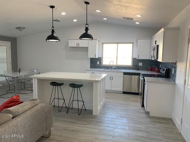 1706 West Colt Road Chandler, AZ 85224 - Photo 3 of 35 a kitchen with stainless steel appliances granite countertop a stove a sink and a microwave