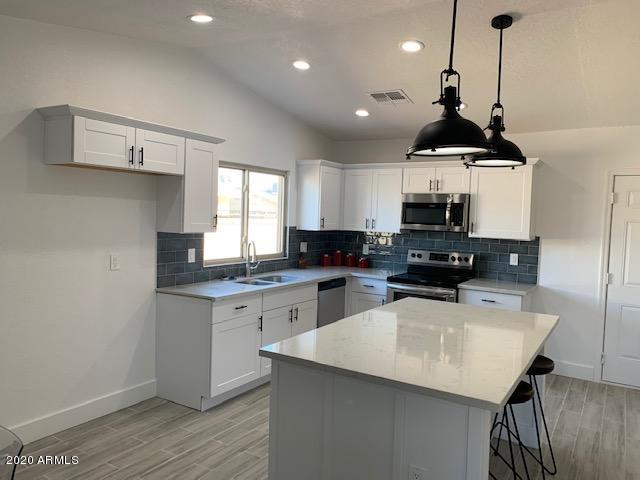 1706 West Colt Road Chandler, AZ 85224 - Photo 5 of 35 a kitchen with kitchen island granite countertop a sink a counter space appliances and cabinets