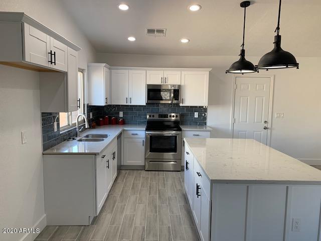 1706 West Colt Road Chandler, AZ 85224 - Photo 6 of 35 a kitchen with a sink a stove and cabinets