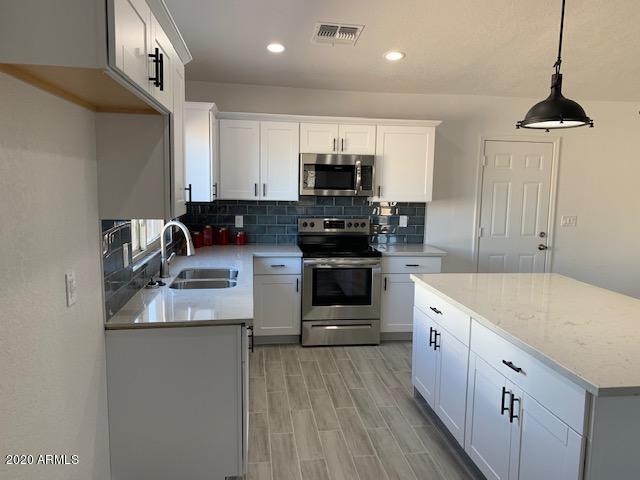 1706 West Colt Road Chandler, AZ 85224 - Photo 7 of 35 a kitchen with a sink stove and cabinets