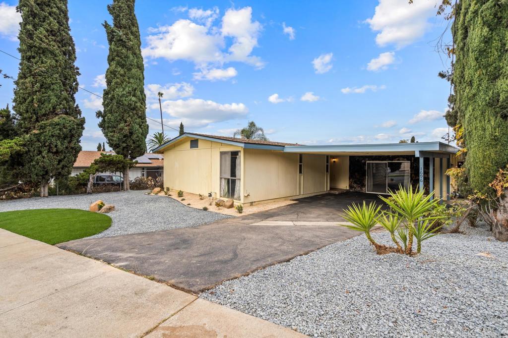 1696 Bartram Way El Cajon, CA 92019 - Photo 27 of 35 a view of a house with a yard and table and chairs under an umbrella