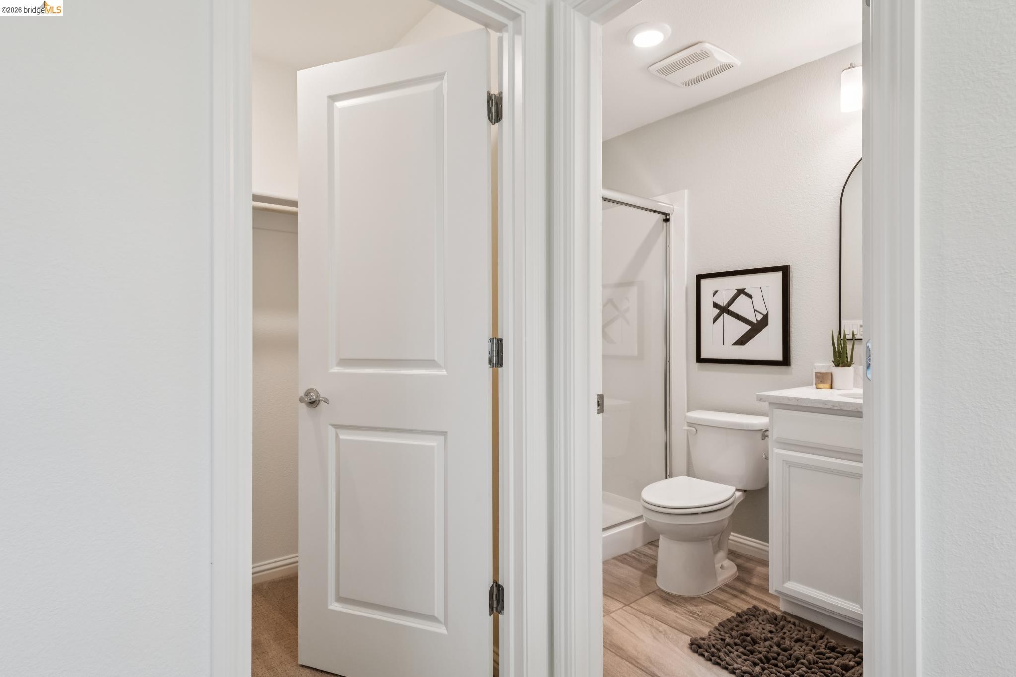 24157 Amaranth Loop Hayward, CA 94541 - Photo 11 of 63 Bathroom featuring a walk-in shower with glass enclosure, white vanity with countertop, and wood-finish flooring