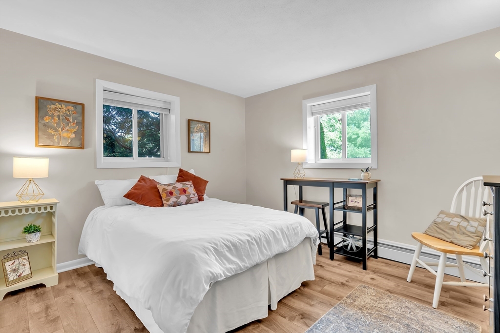 22 Bryon Road, Unit 1 Boston, MA 02467 - Photo 11 of 19 a bedroom with a bed a table and chair