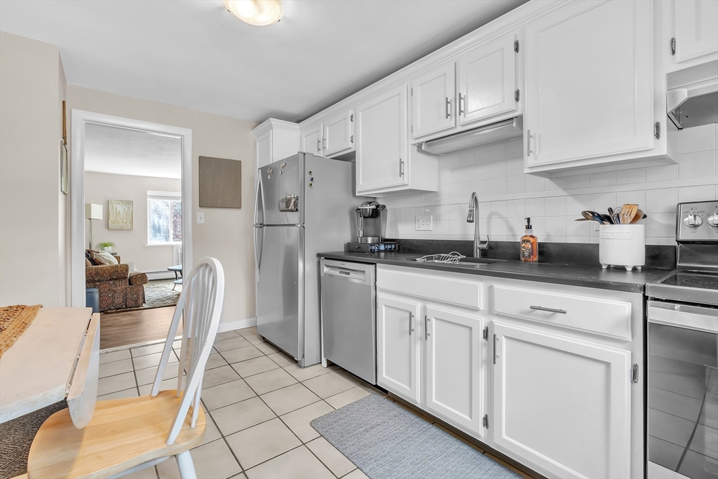 22 Bryon Road, Unit 1 Boston, MA 02467 - Photo 4 of 19 a kitchen with white cabinets and appliances