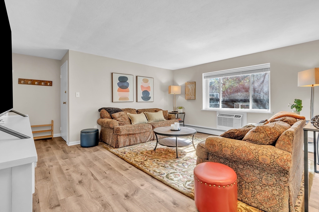 22 Bryon Road, Unit 1 Boston, MA 02467 - Photo 8 of 19 a living room with furniture a couch and a large window